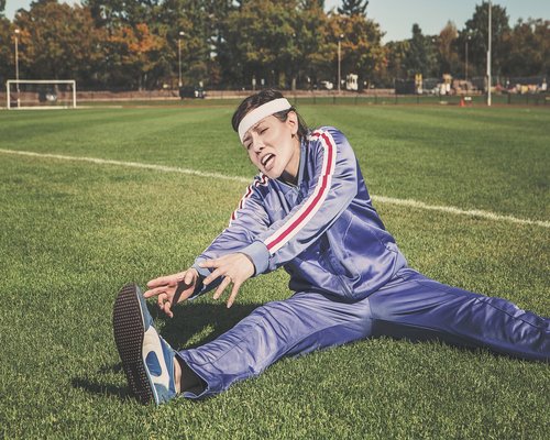 Man stretching and exercising outdoors in sunlight
